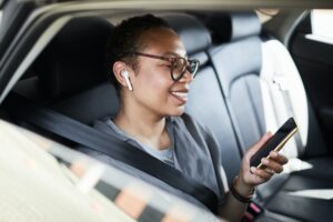 Business woman using phone in car from Dunat Tours and Car Rental.